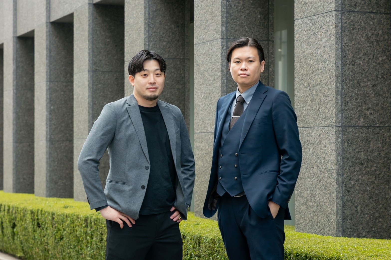 オフィス前で並んで立つBLAYNの社員2名